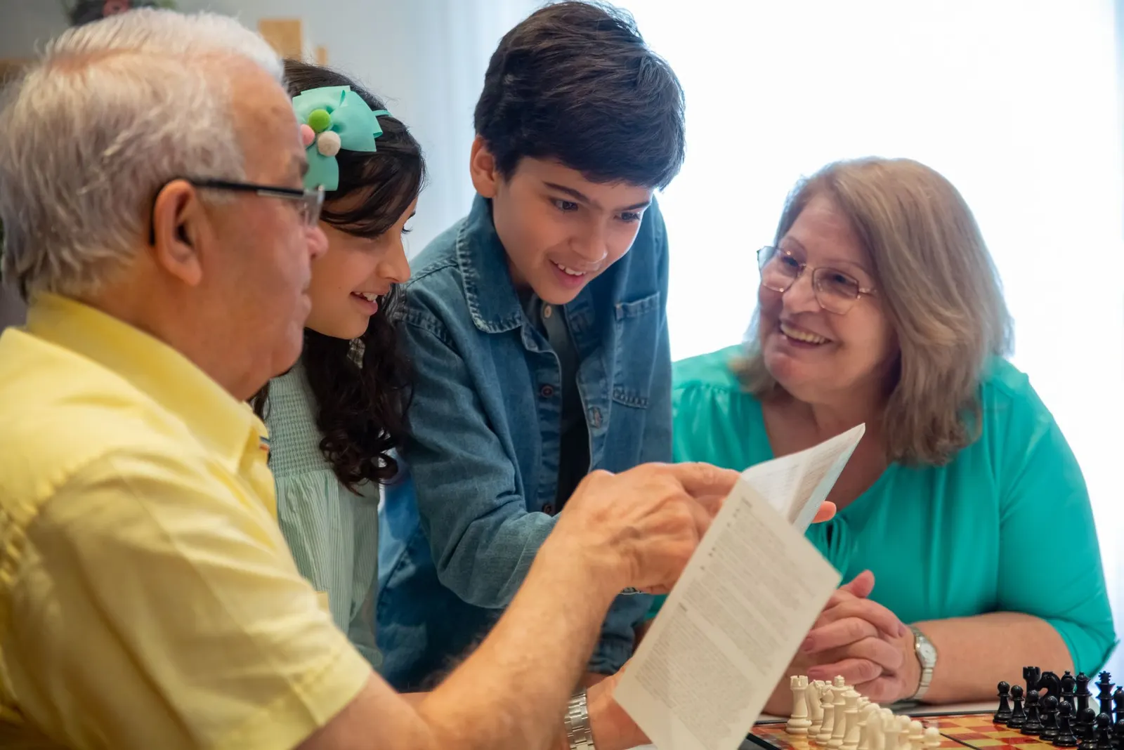 Grandparents and grandchildren looking at a printed page together