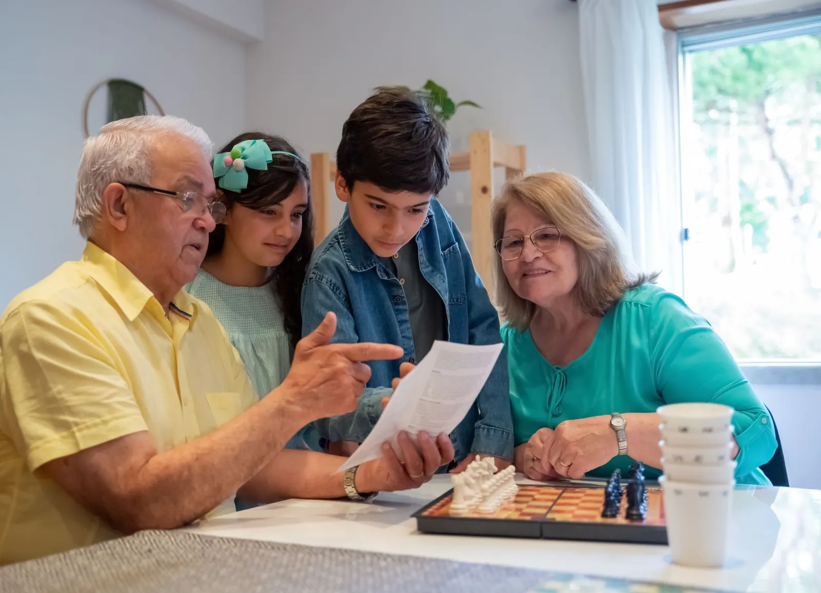 Grandparents and grandchildren round a table, working out the family story together