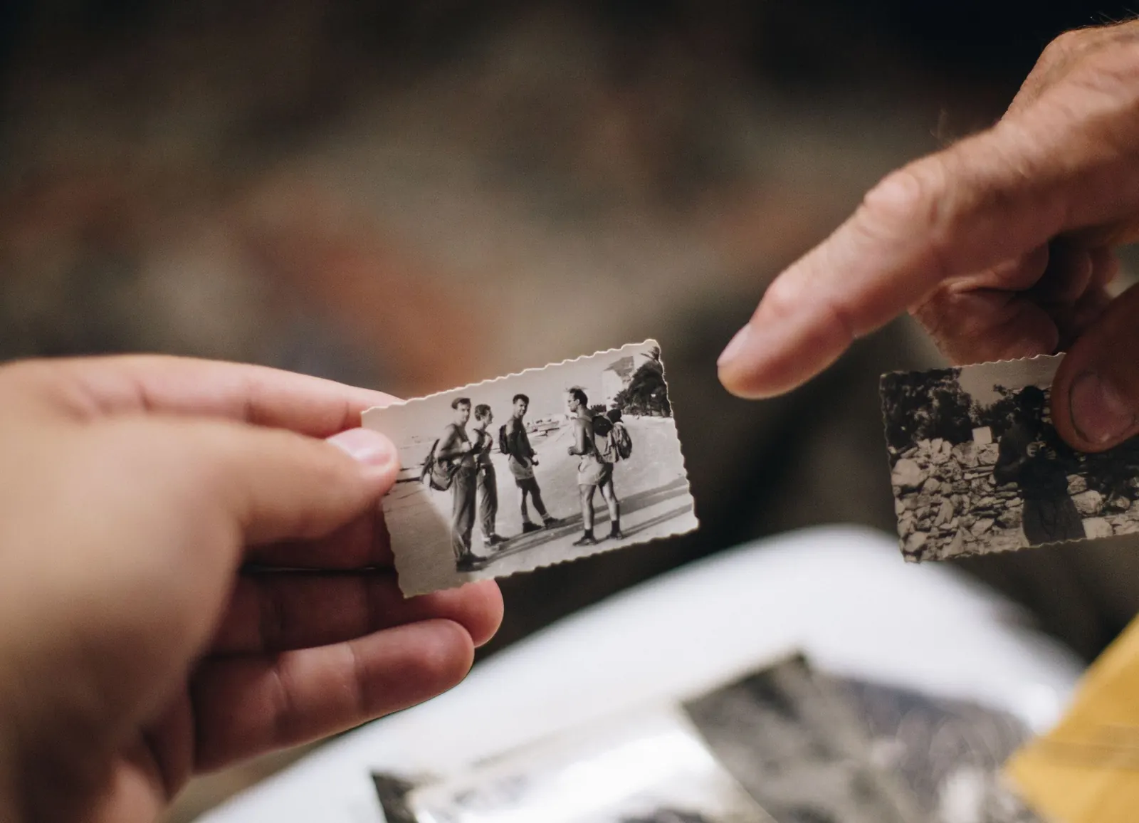 Two hands holding old black-and-white photographs