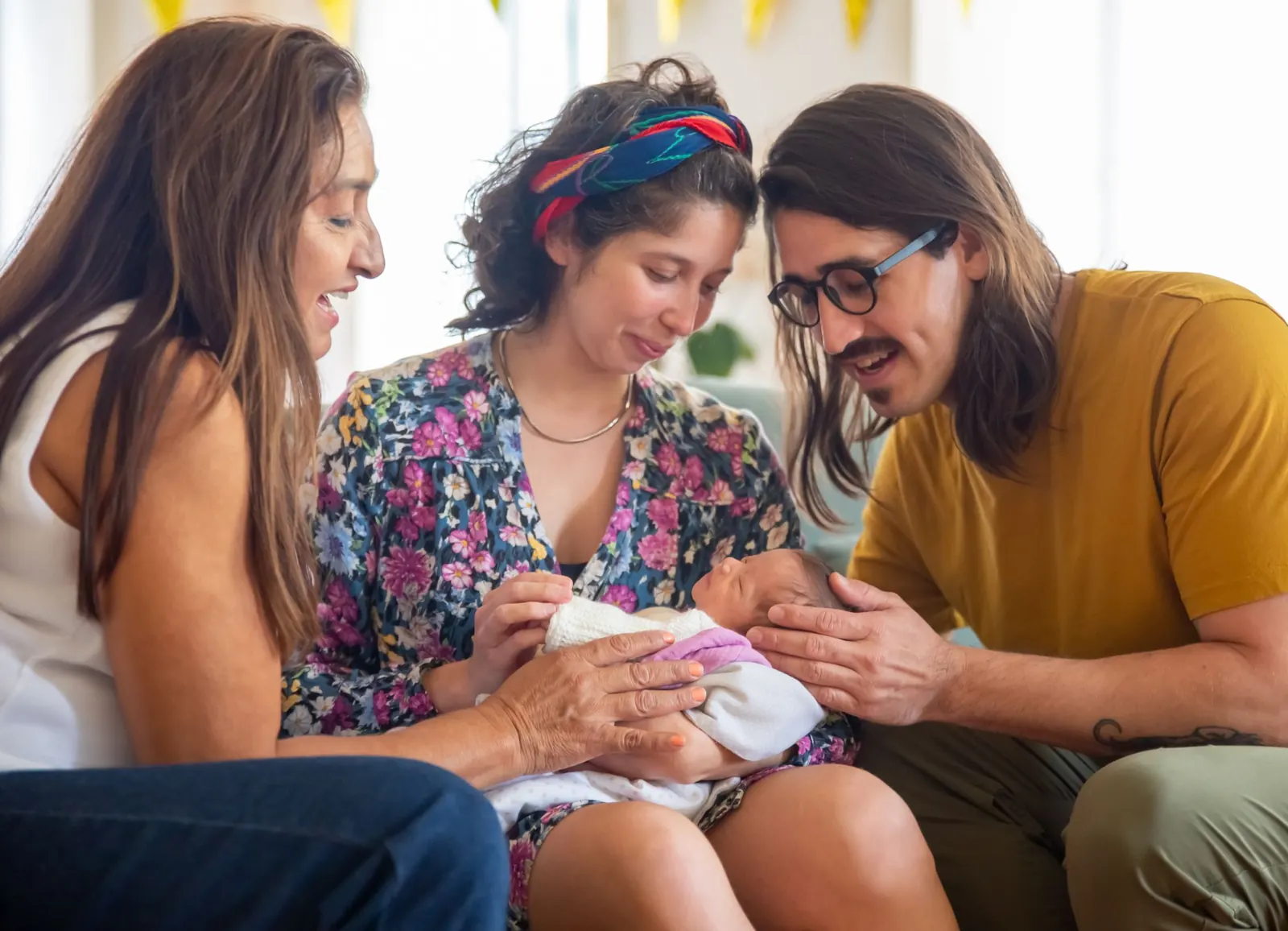 New parents introducing their baby to a grandparent at home